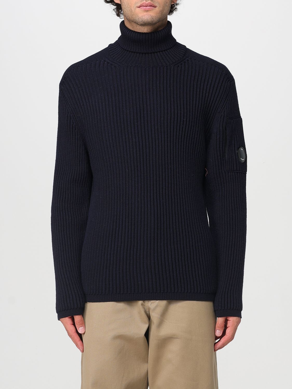 C.p. Company Ribbed Knit Roll Neck Sweater With Signature Lens Detail And Zip Pocket In Black