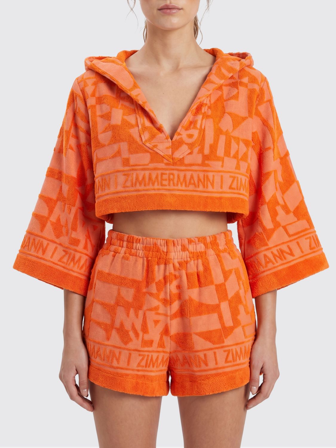 ZIMMERMANN Top cropped Solstice in cotone a maniche lunghe con cappuccio